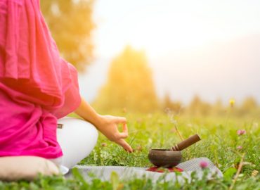 Tibetan bell beside yoga position in a meadow the sun
